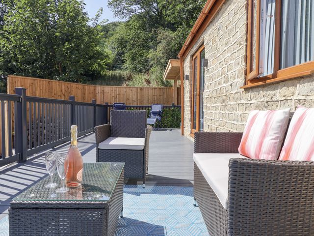 An outdoor seating area with a coffee table and sofa at Woodside in Scarborough