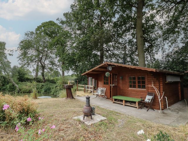 An outdoor area with a cabin and seating at Carps Well Lodge in Hatton near Shrewley
