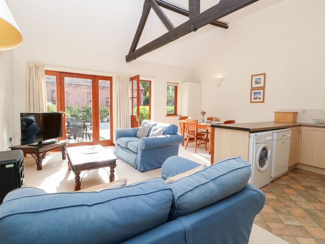 A living room with a sofa and dining area at Holly Berry near Wood Norton Foulsham