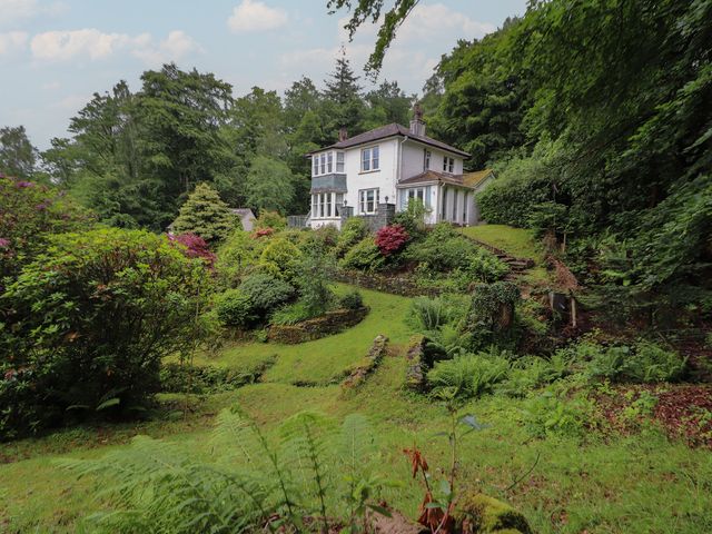 A house surrounded by a garden with trees and bushes at High Cross in Keswick