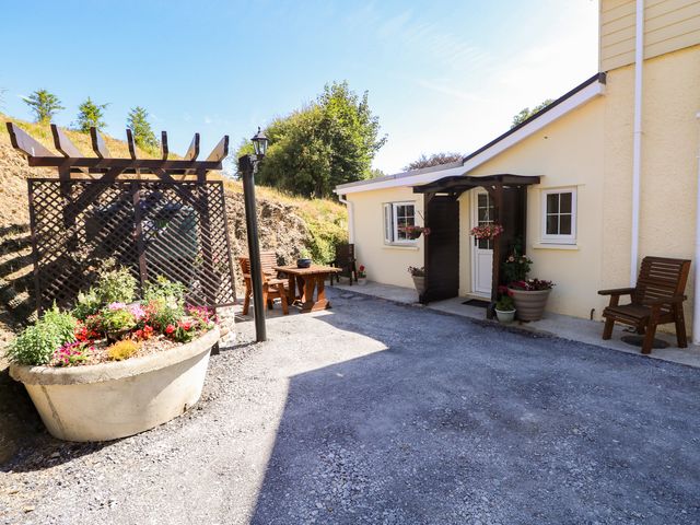 An outdoor area with a flower bed and seating at Dolcoed Manordeilo near Llangadog
