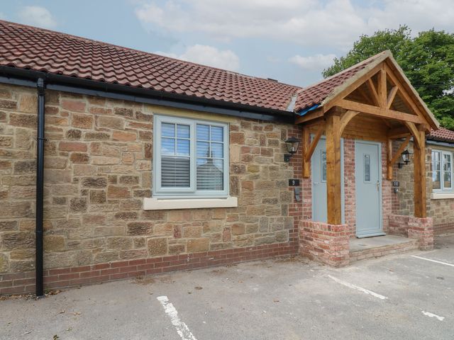 An exterior view of a stone building with a porch at Cottage 9 in Brandon, County Durham