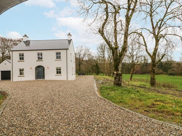 A house with a garage and a gravel driveway at Cloneytrace Mines in Broughshane