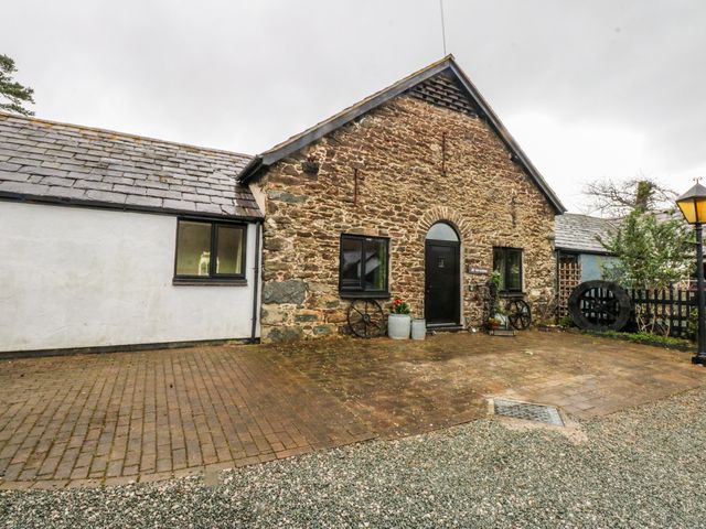 An outdoor view of a stone building with a door and windows at Pen Glorian in Conwy
