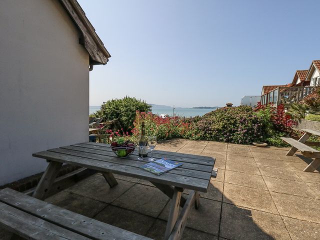 An outdoor area with a table, bottle and glasses at Sea Spray in Bowleaze