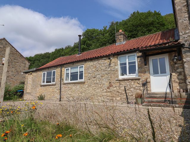 A house with stone walls and a red roof at St Gregory’s Cottage in Oswaldkirk near Helmsley