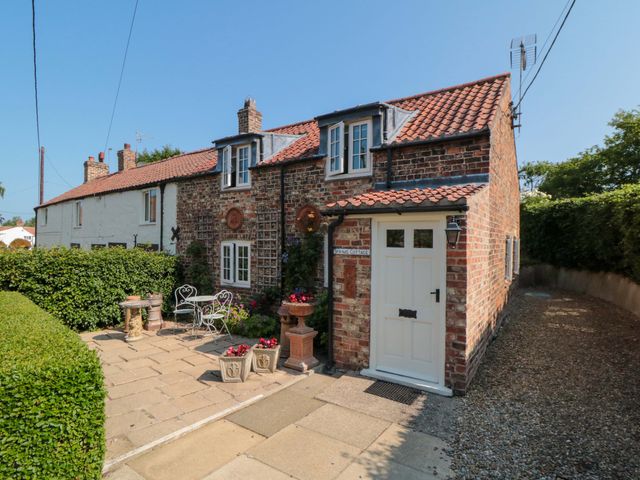A cottage exterior with a garden seating area at Spring Cottage in York