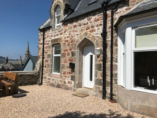 An outdoor area with a stone wall and bench at View Cottage in Inverness