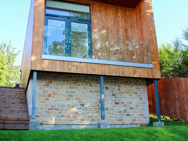An outdoor view of a building with a balcony and stone wall at View Apartment in Inverness