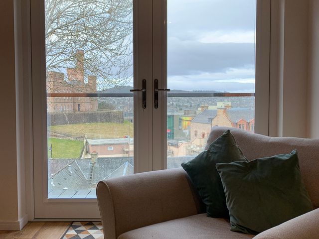 A living room with a view of buildings outside at View Apartment in Inverness