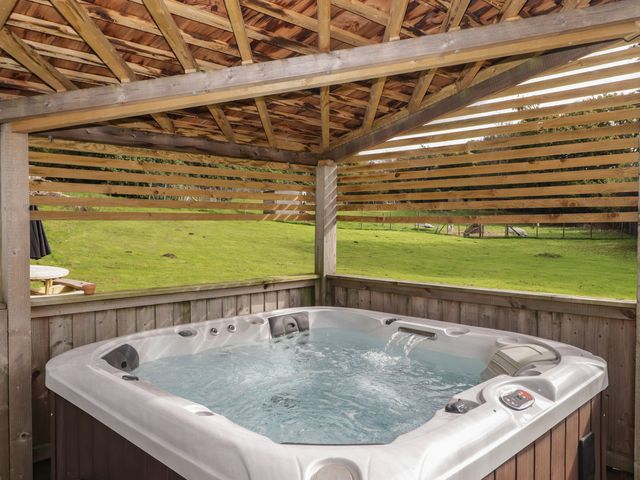 A hot tub in a wooden structure in an outdoor area at The Lodge in Bridgend