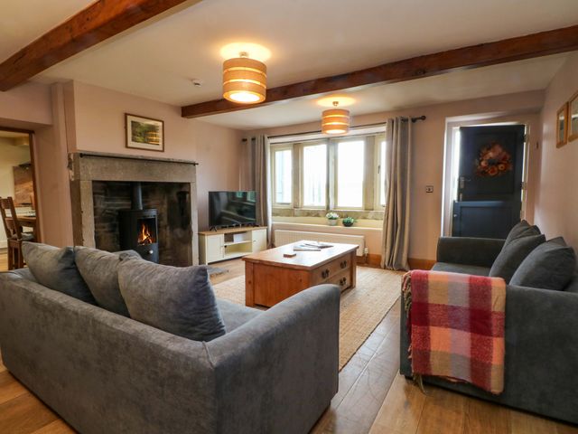 A living room with a sofa and coffee table at Stone & Fleece Cottage in Holmbridge