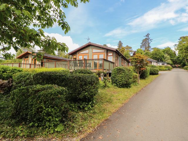 A lodge with decking and hedges along a road at 28 Troutbeck in Bassenthwaite