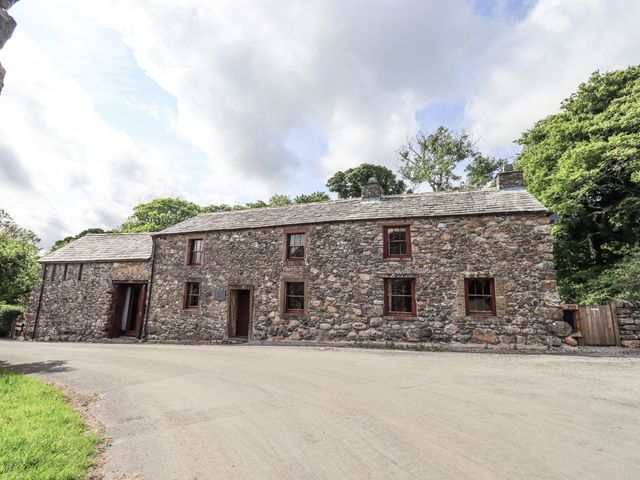 A stone building with windows and doors at Chapel Cottage in Ennerdale near Cleator Moor