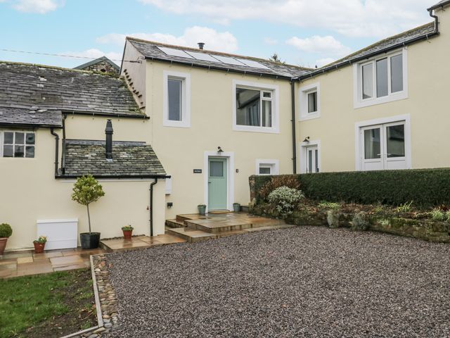 An outdoor view of a house with a gravel area and steps at Swift Barn in Wigton