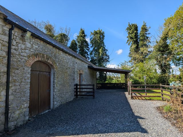 An outdoor area with a stone building and wooden door at Woodville Lodge in Rhode