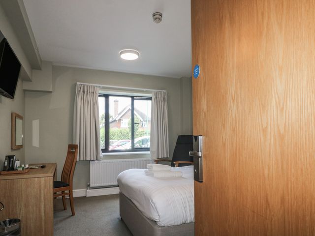 A bedroom with a bed and chair at Bedroom 4 in Littlehampton