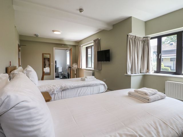 A bedroom with two beds and a television at Bedroom 6 in Littlehampton