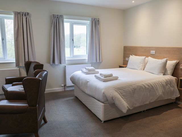 A bedroom with a bed and two chairs at Bedroom 36 Penrith