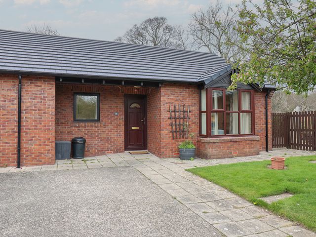 An entrance to a bungalow with a pathway and garden at Bungalow 15 Eamont Park in Penrith