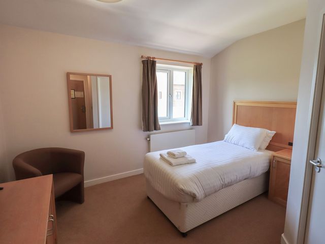 A bedroom with a bed and a desk at Eamont Park Ground-floor Single Bedroom in Penrith