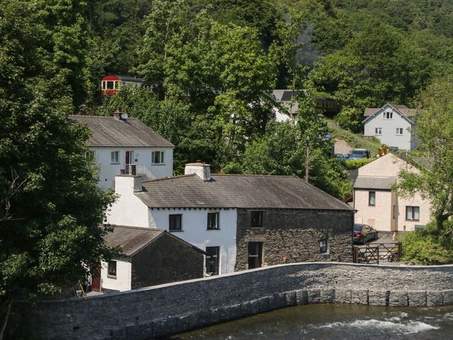 A view of houses and trees with a train in the background at Old Post Office Cottage Ulverston