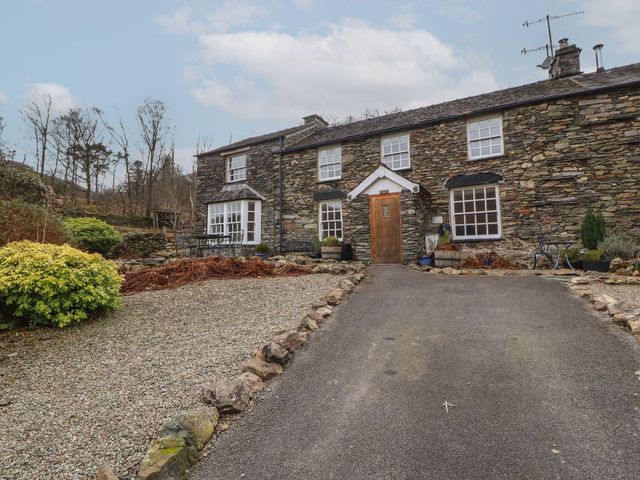 A house with stone walls and a gravel driveway at Deer How Farm in Patterdale near Glenridding