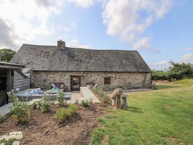 A barn with pathway and outdoor seating at The Long House Near Trefonen