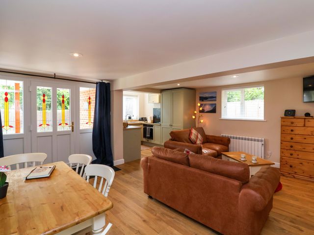 A living room with a table and chairs at Poddington Cottage
