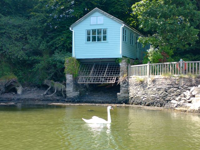 A house on stilts beside water at The Sharpham Boat House in Ashprington