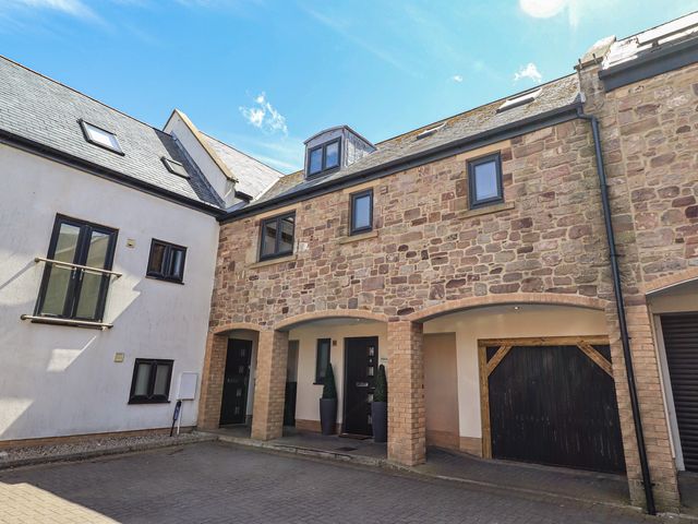 An exterior view of a property with multiple windows and a door at Craster House in Seahouses