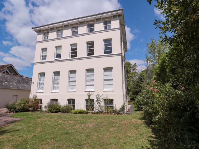 A building exterior with windows and grass at Flat 2 Battledown Grange in Cheltenham
