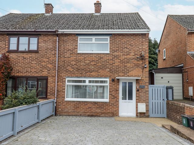 A brick house with windows and a driveway at Milana in Tiverton