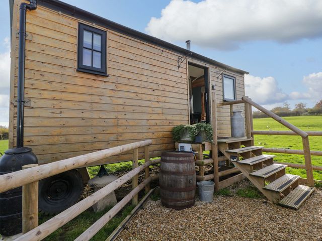 A wooden cabin with steps and barrels at Wiltshire Weavers Hut Sutton Benger near Christian Malford