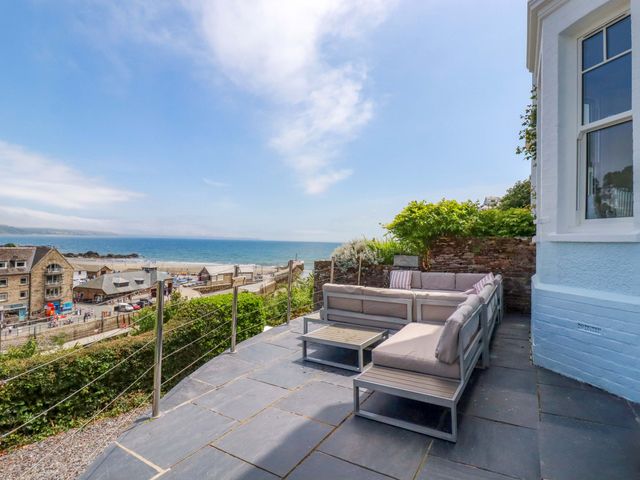 An outdoor seating area overlooking the sea at Harbour House in Looe