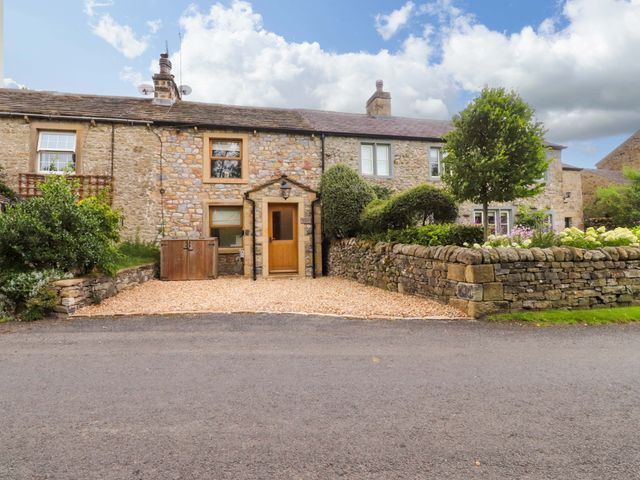 A cottage with a pathway and garden at Welly Bob Cottage in Airton