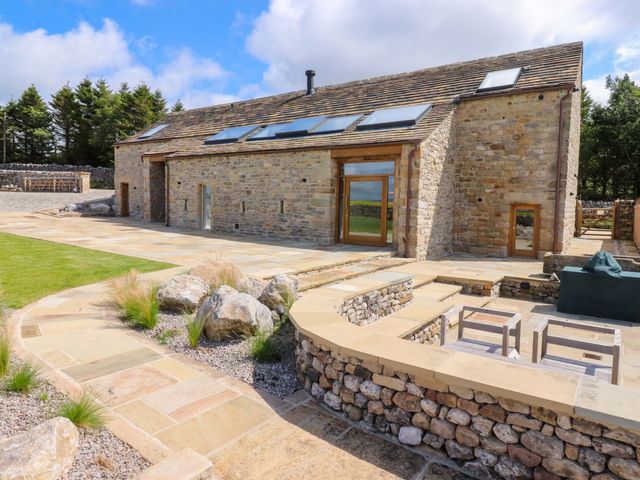 A barn with stone walls and a patio area at Carden Laithe Barn Threshfield