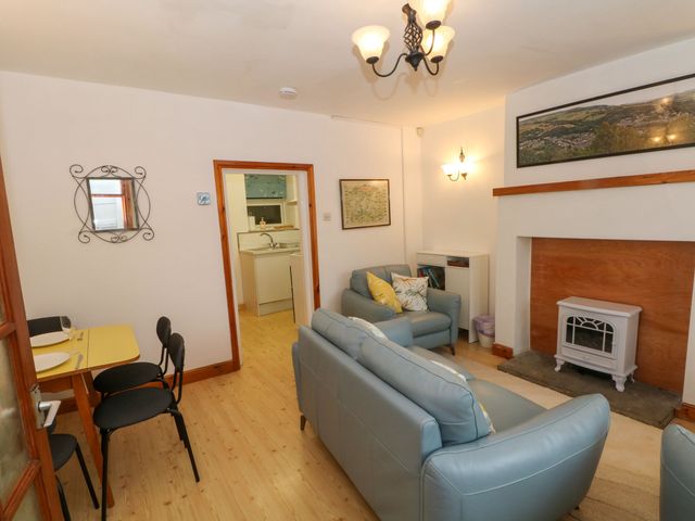 A living room with a sofa and a table at Holme Cottage Hebden Bridge