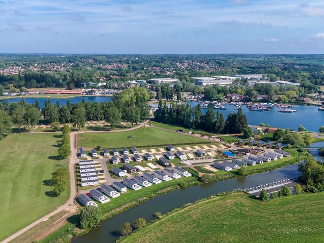 An aerial view of a holiday park with rows of cabins near water at Willowbrook Hideaway - Billing Aquadrome
