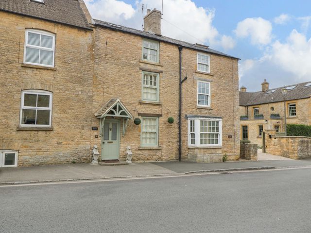 An exterior view of a stone building with windows and a front door at The Cottage in Stow-On-The-Wold