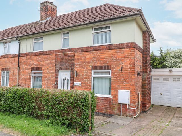 A brick semi detached house with white windows and a garage at 46 Dalby Road in Antsey