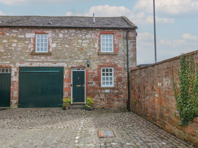 An outdoor area with a building and garage at The Old Coach House in Lochmaben