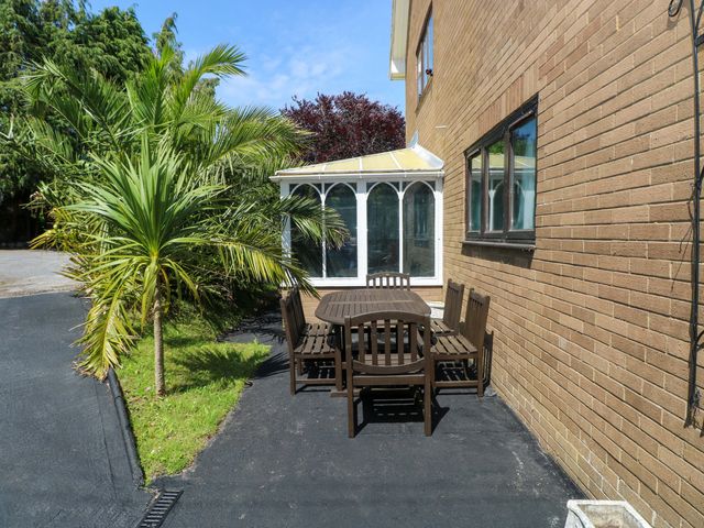 A garden area with a table and chairs beside a conservatory at 170 Langland Road Mumbles