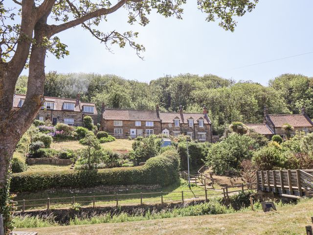 A row of houses with gardens and trees at Rigg Cottage in Sandsend