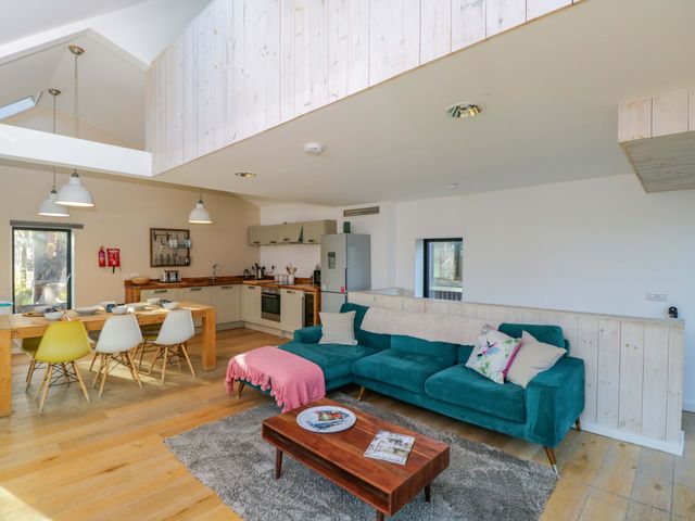 A living room with a sofa and dining area at 4 The Stoneyard in Bath