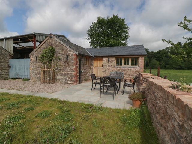 An outdoor seating area with a table and chairs at Ynys Pandy near Ewyas Harold