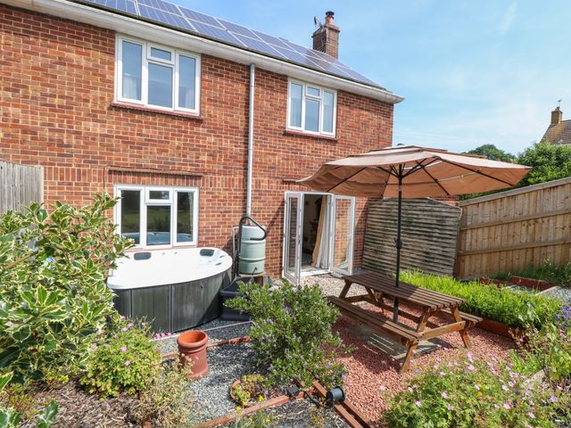 A garden with a hot tub and table at 3 Birkbeck Way in Norwich