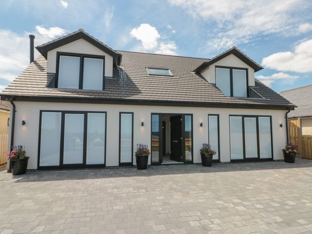 A house with multiple windows and planters at Puffin Lodge in Hunmanby