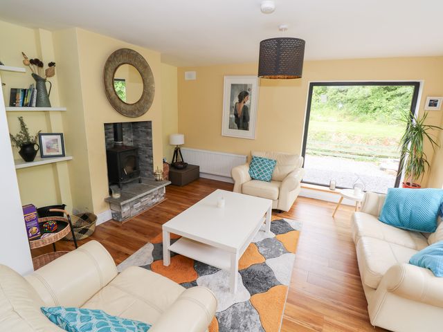 A living room with a fireplace and large window at Huath in Carrick on Shannon