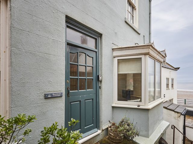 An entrance with a blue door and a sign at Beachside Cottage Sandsend